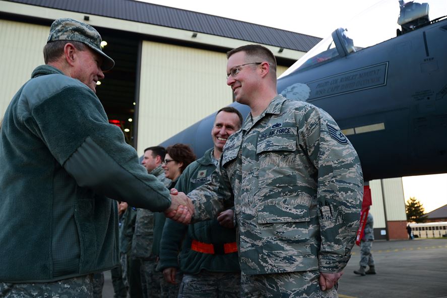 Military Men shaking hands in front of a helicopter