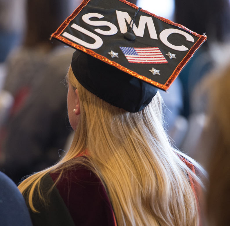 Student Veteran graduating with grad cap saying USMC.