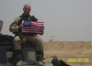 Brian Collins deployed holding american flag.