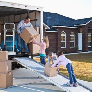 family moving boxes into moving truck.