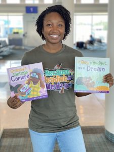 Jasmine Paul holding up children's books.