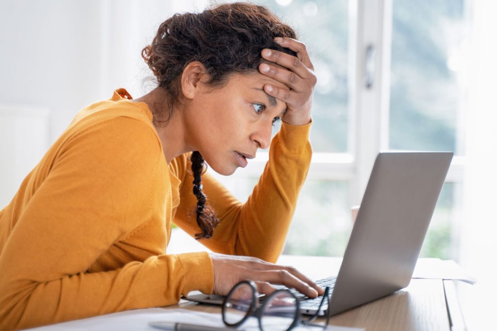 Women looking at her laptop stressed. 