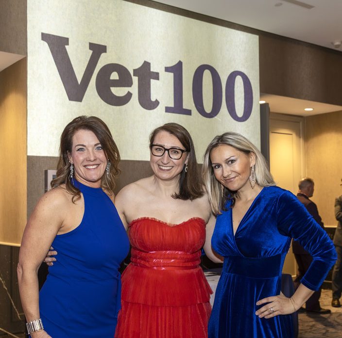 Three vet100 participants posing in front of vet100 signage. Three vet100 participants posing in front of vet100 signage.