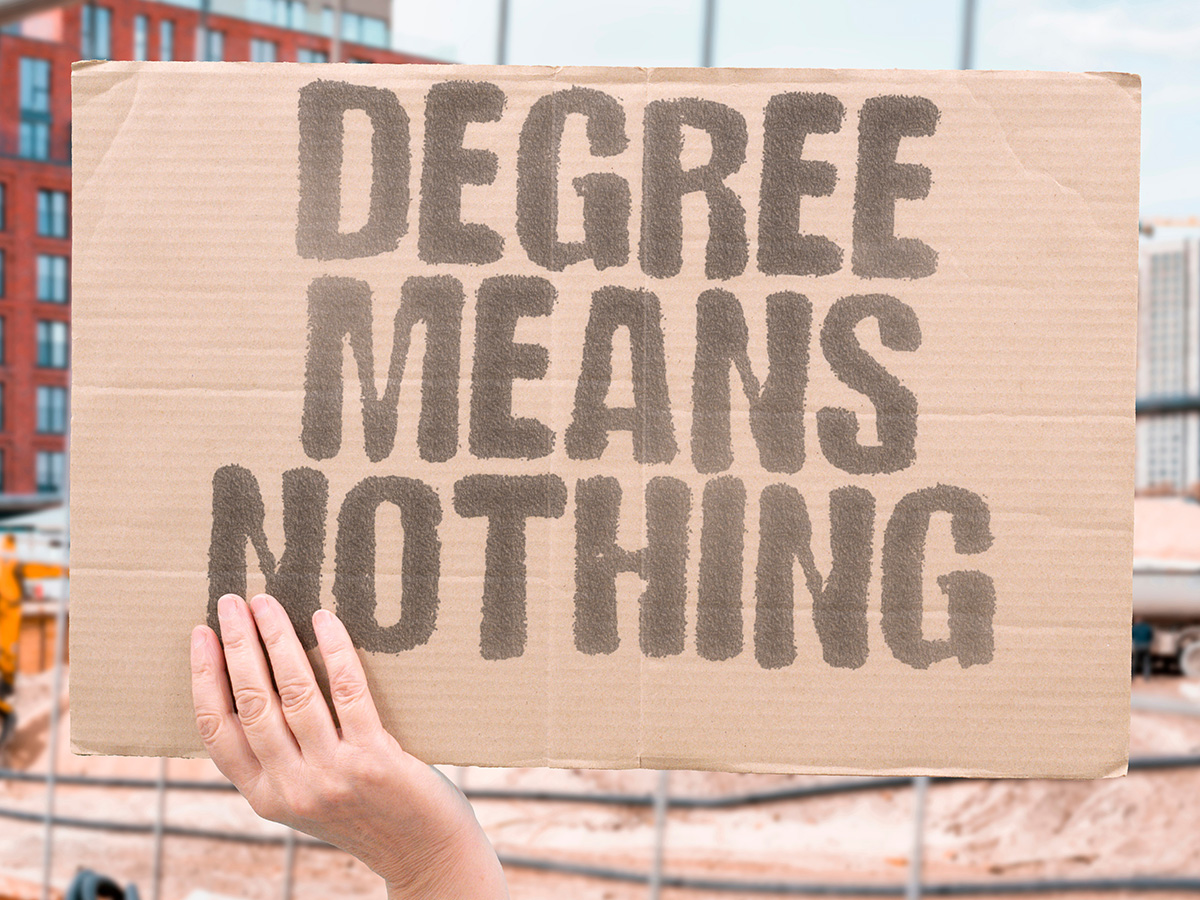 Cardboard sign that says "Degrees mean nothing"