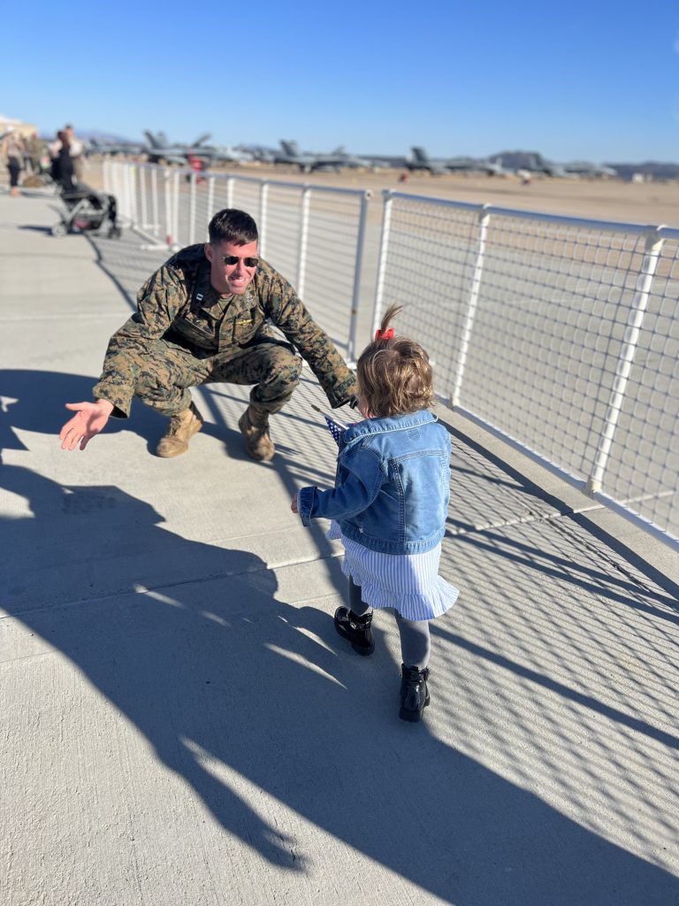 Melanie Vernoia husband's holding his arms open for their daughter to hug.