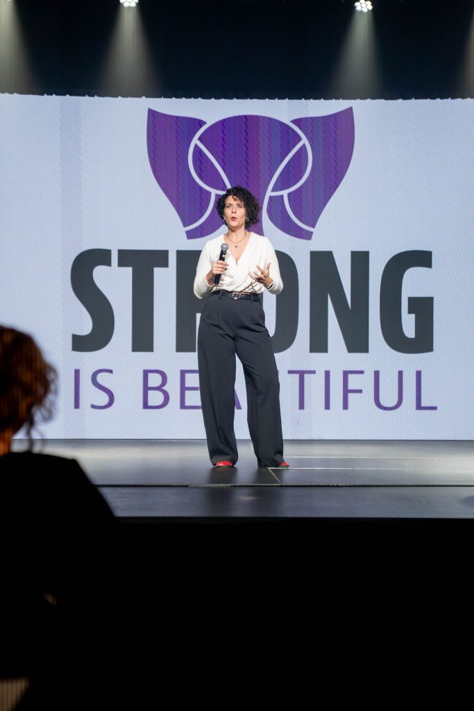 Alison on stage talking about her company Strong is beautiful