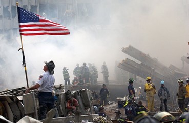 fireman saluting american flag at ground zero.